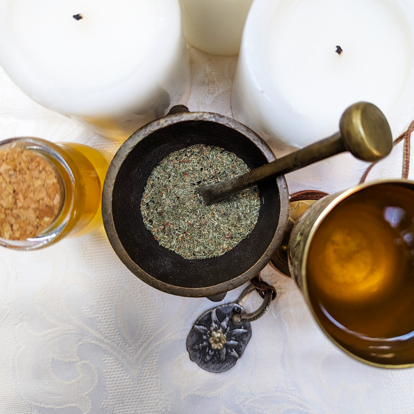 A top-view of a brass mortar and pestle, filled with fine and complex herbal blend.