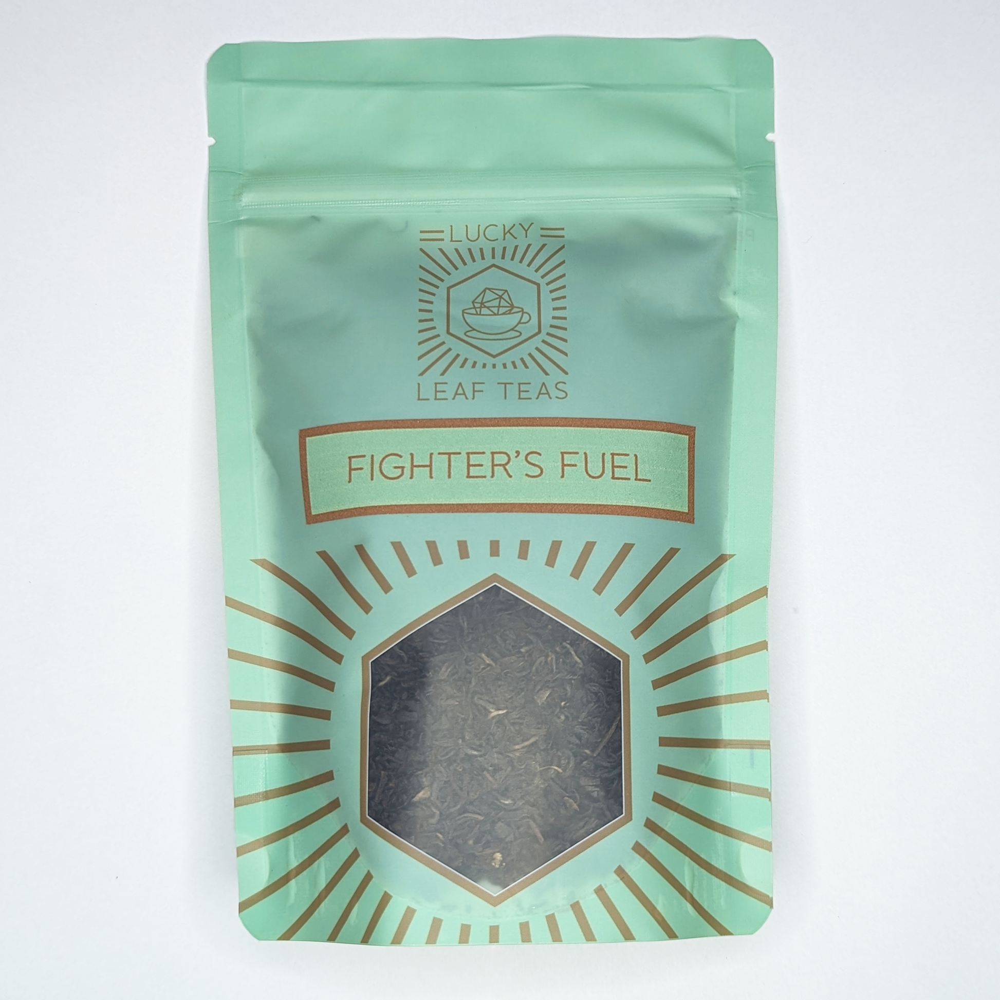 A mint-green package containing 100g of Fighter’s Fuel: a black tea blend. The name is stickered on the front, below the Lucky Leaf Teas Logo and above a hexagonal window displaying the tea.