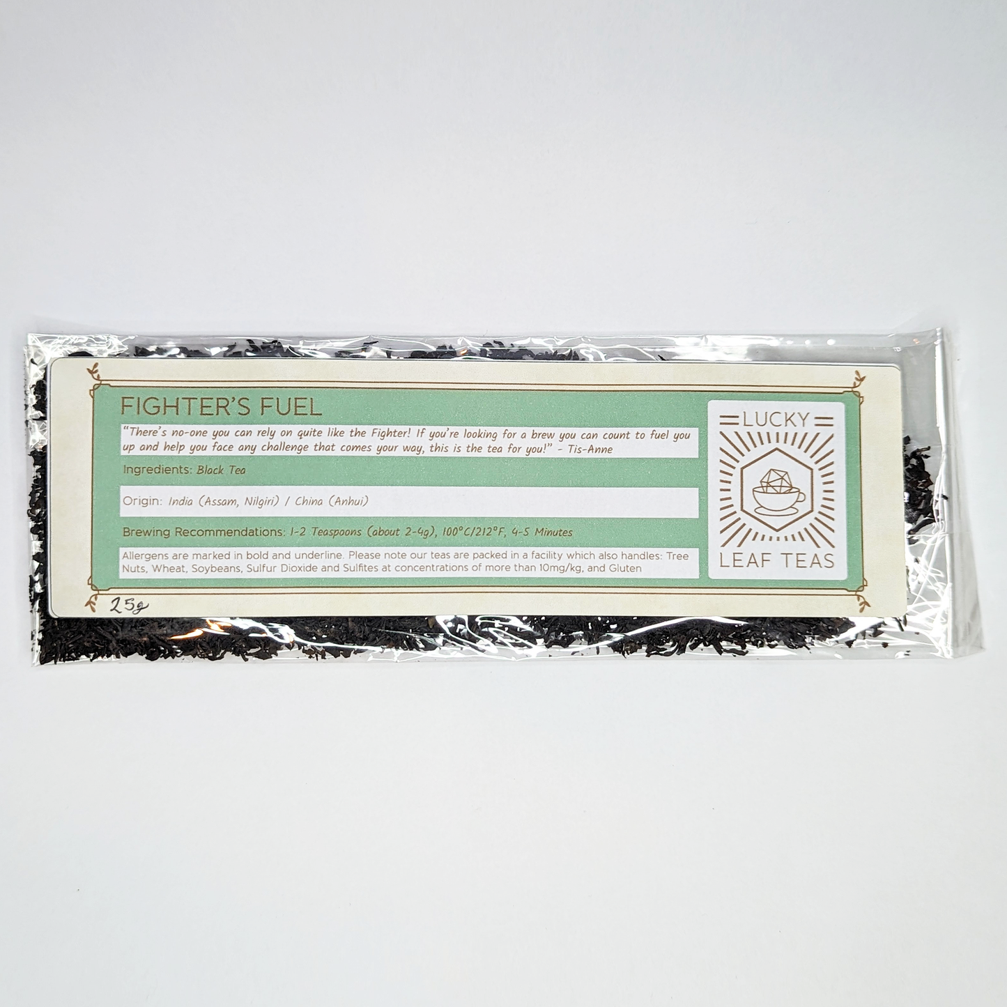 A slim, see-through package containing 25g of Fighter’s Fuel: a black tea blend. A label with the name, ingredients, origin and brewing recommendations is printed on the front, next to the Lucky Leaf Teas Logo.