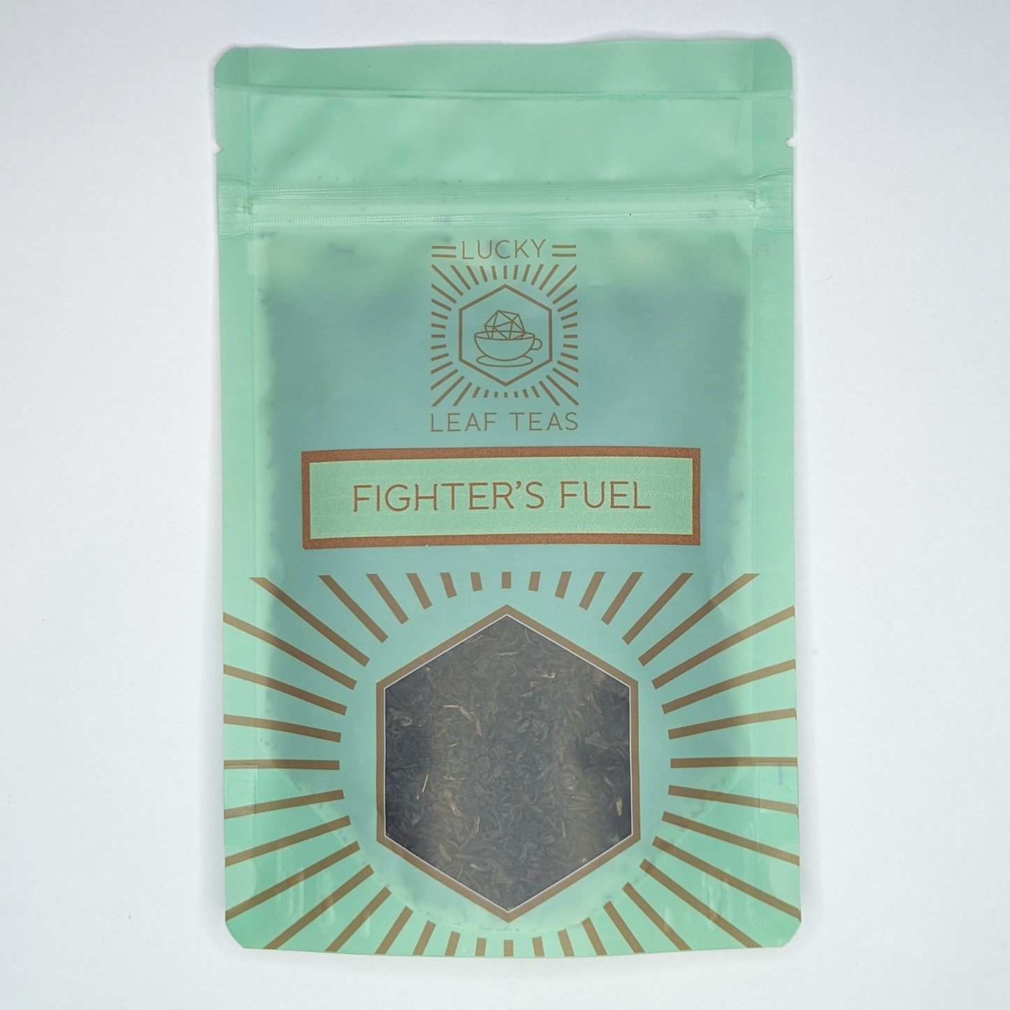 A mint-green package containing 50g of Fighter’s Fuel: a black tea blend. The name is stickered on the front, below the Lucky Leaf Teas Logo and above a hexagonal window displaying the tea.