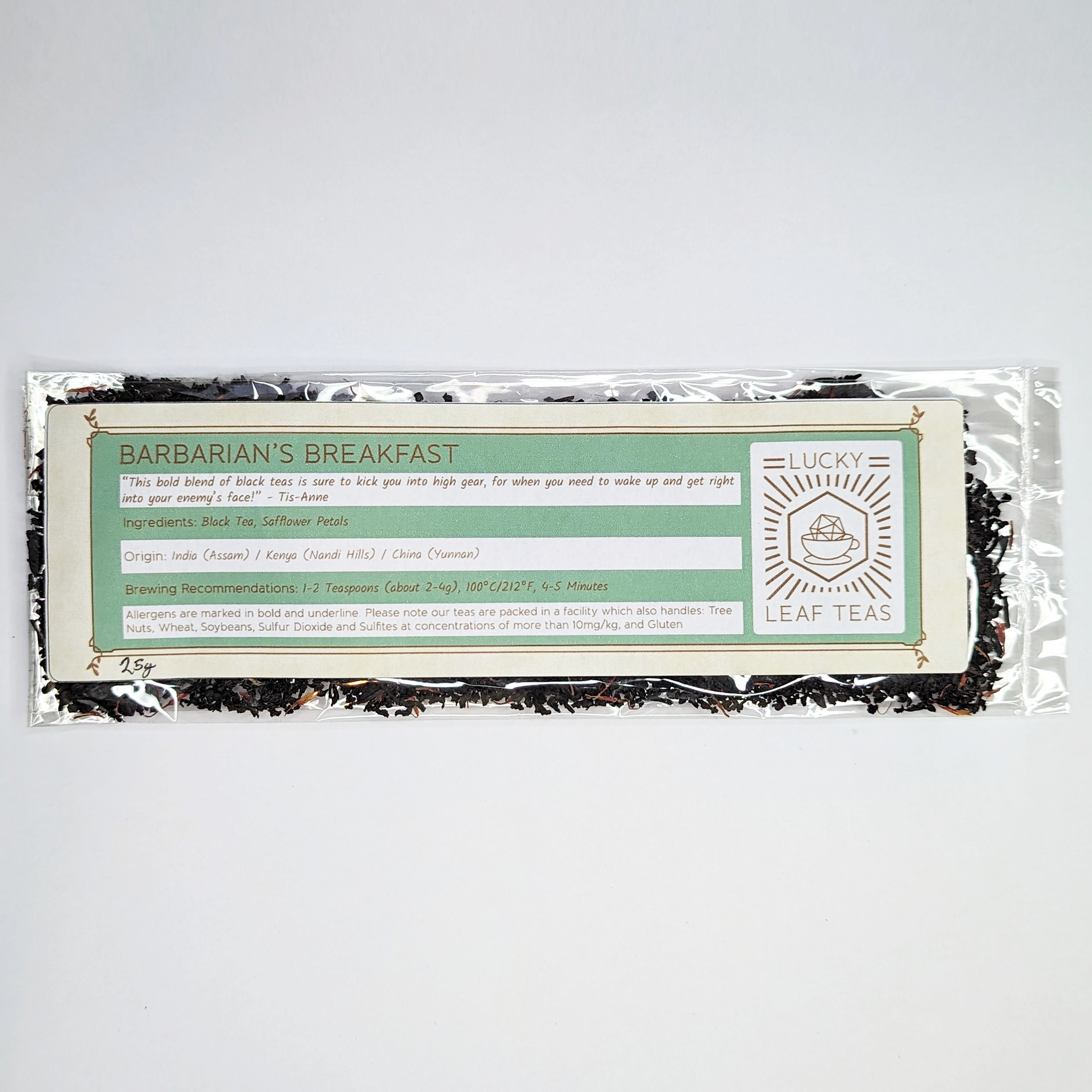 A slim, see-through package containing 25g of Barbarian's Breakfast: a black tea blend with visible red safflower petals. A label with the name, ingredients, origin and brewing recommendations is printed on the front, next to the Lucky Leaf Teas Logo.