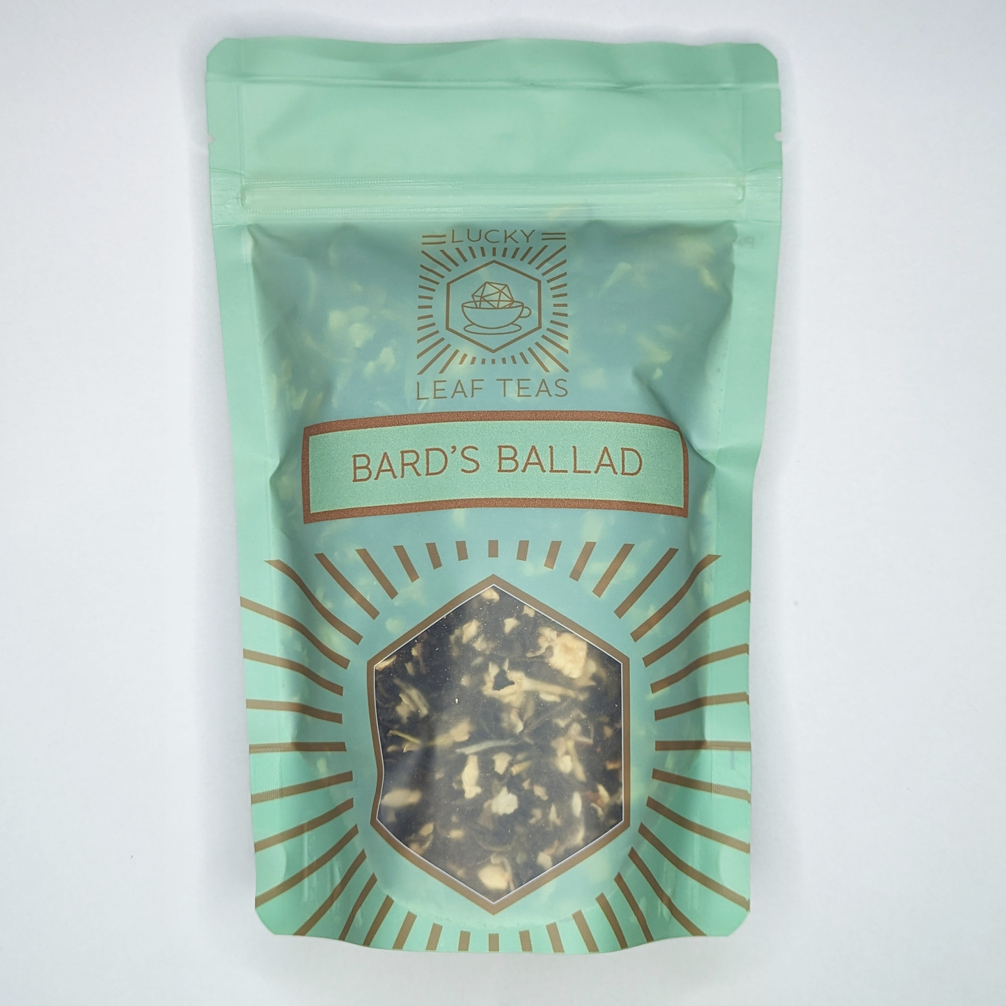 A mint-green package containing 100g of Bard’s Ballad: a green tea blend with visible jasmine flowers. The name is stickered on the front, below the Lucky Leaf Teas Logo and above a hexagonal window displaying the tea.