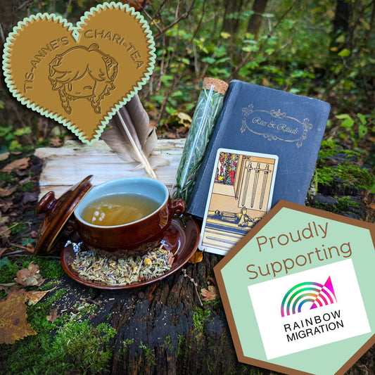 A brown-glazed bowl filled with a clear, amber-yellow liquid. It sits on a matching saucer, which has a scattering of leaves and flowers upon it. To the right is a "Four of Swords" tarot card, a pair of feathers, a corked vial filled with a fresh herb, and a blue book titled "Rites and Rituals."

A heart-shaped badge in one corner reads "Tis-Anne's Chari-Tea", and another emblem reads "Proudly Supporting" with the logo for Rainbow Migration.