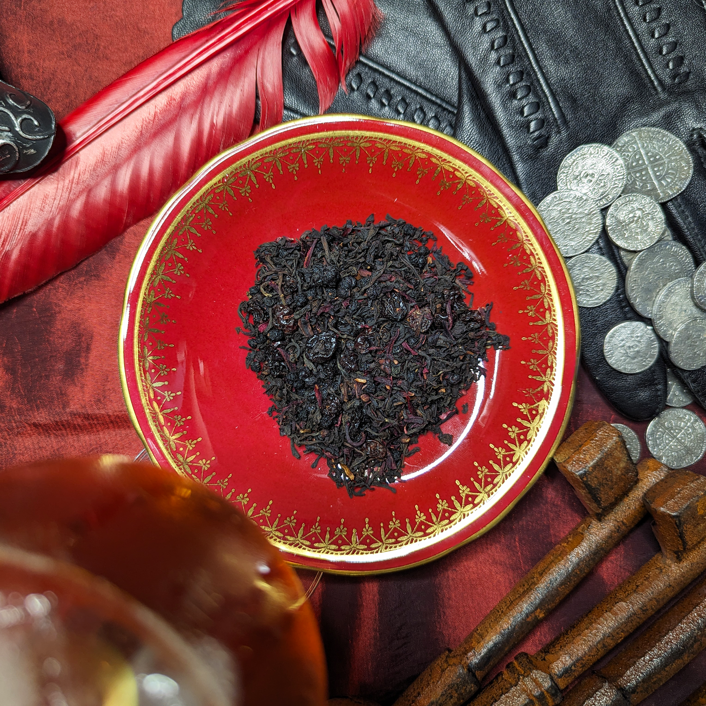 A red saucer with a mound of tea leaves in the middle, which are blended with dried currants and flowers.