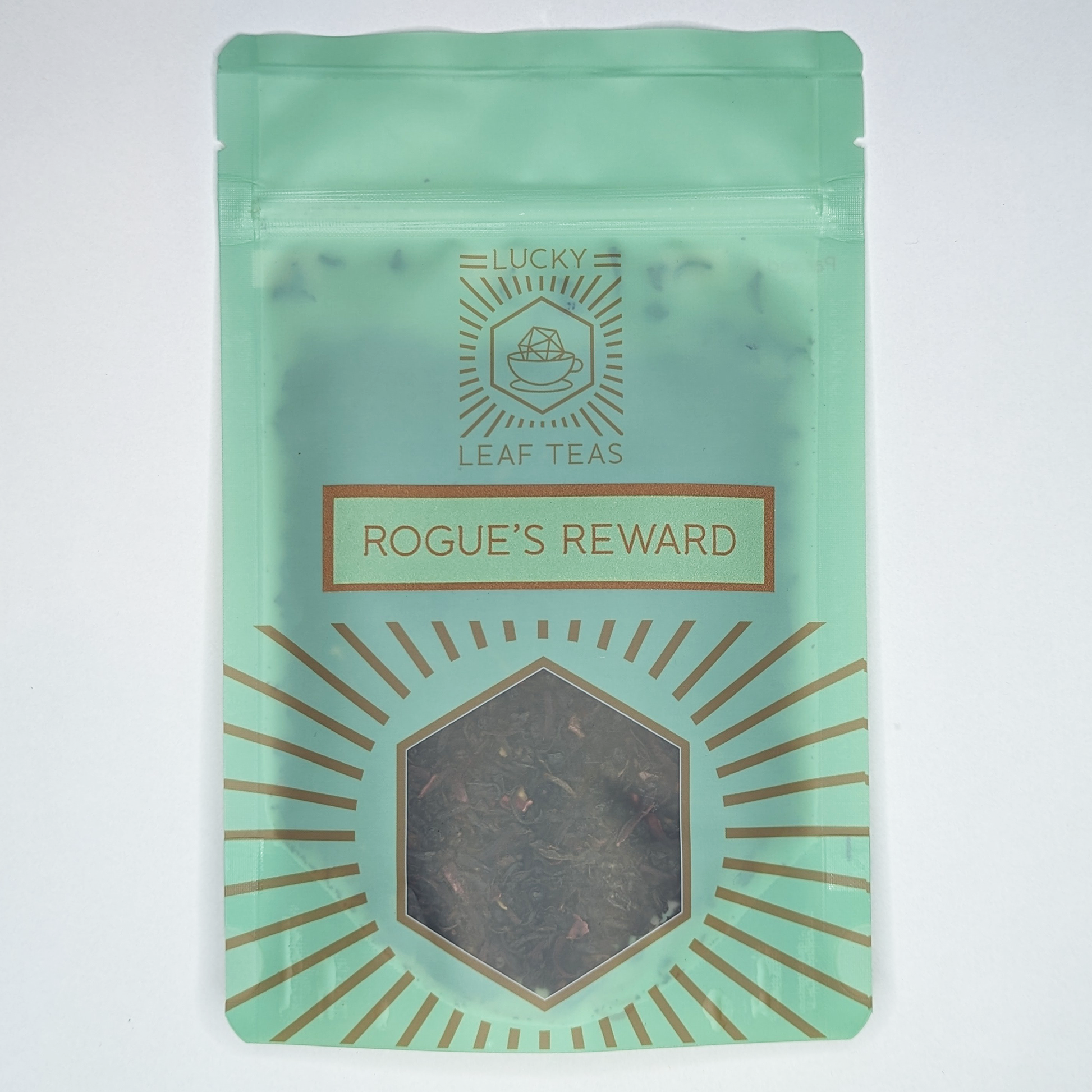 A mint-green package containing 50g of Rogue’s Reward: a black tea blend with visible dried berries and hibiscus petals. The name is stickered on the front, below the Lucky Leaf Teas Logo and above a hexagonal window displaying the tea.